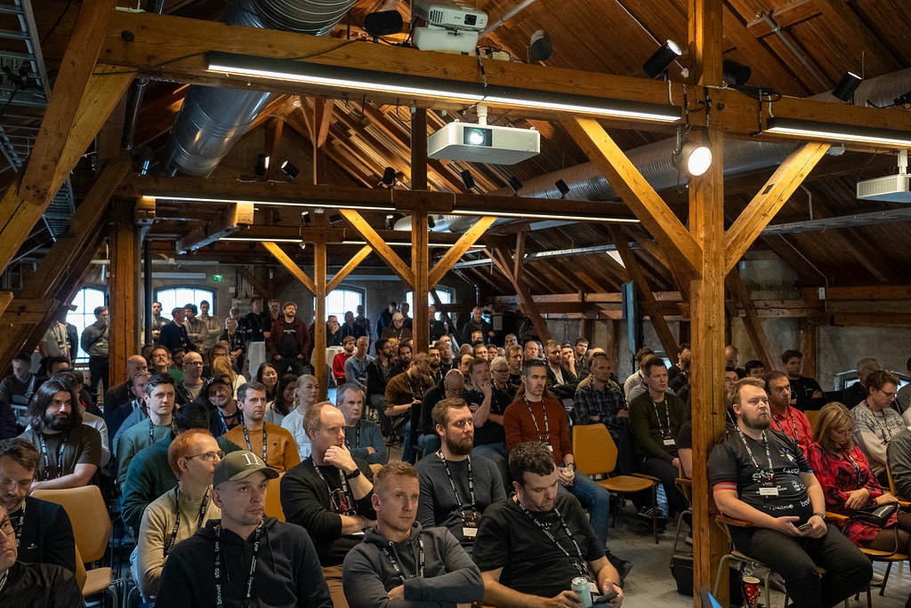 The audience seated beneath wooden beams at Hello Stavanger 2024